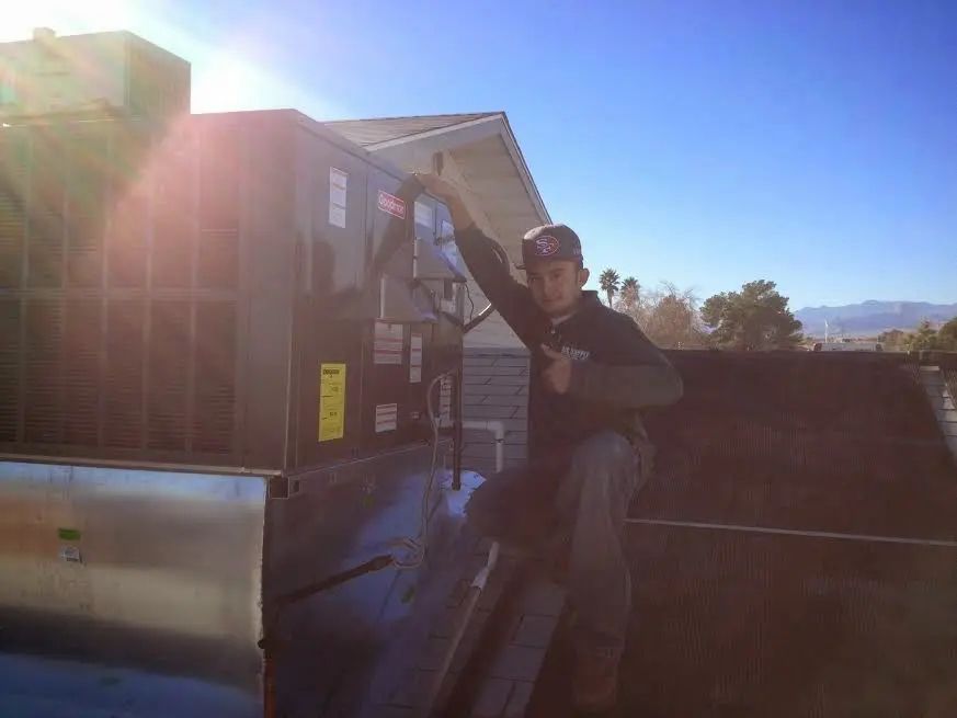 HVAC technician performing HVAC Inspection on a rooftop unit in Lenox